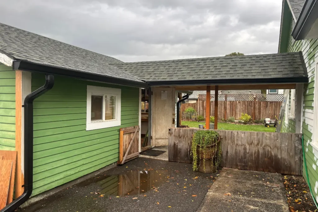 Gutter Installation St Helens 5 Black gutters and downspouts installed on a green home in St. Helens, Oregon