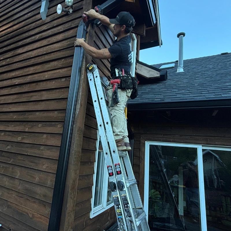 American Gutter Service installer fitting a downspout elbow in St. Helens, Oregon
