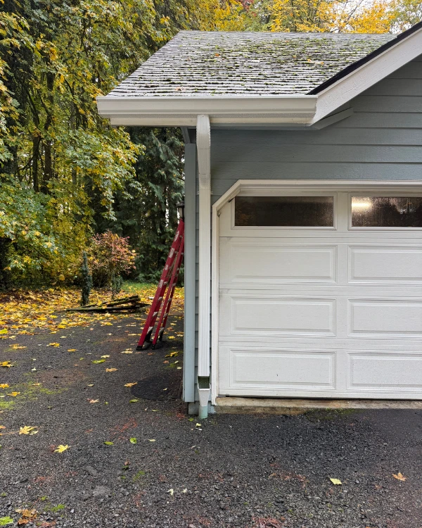 White gutter and downspout installed beside a garage in St. Helens, Oregon