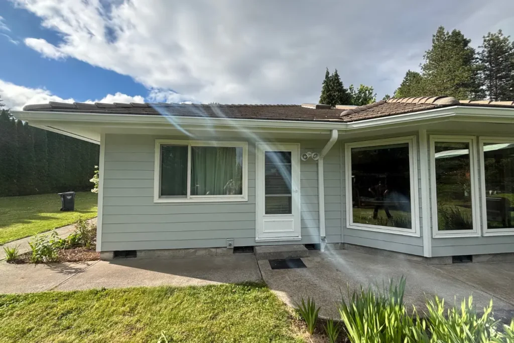Gutter Installation St Helens 7 White rain gutters and downspouts on a gray single-story home in St. Helens, Oregon