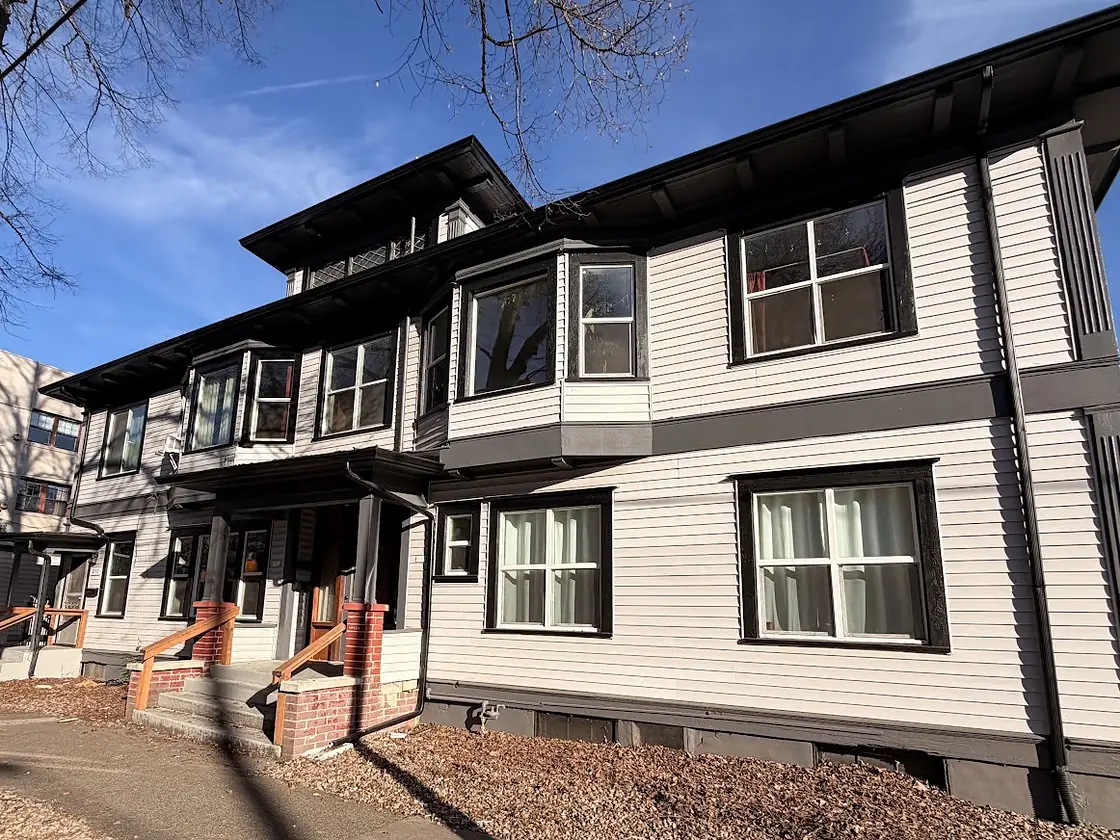 Two-story craftsman home in Portland with black seamless gutters and matching downspouts against light gray siding