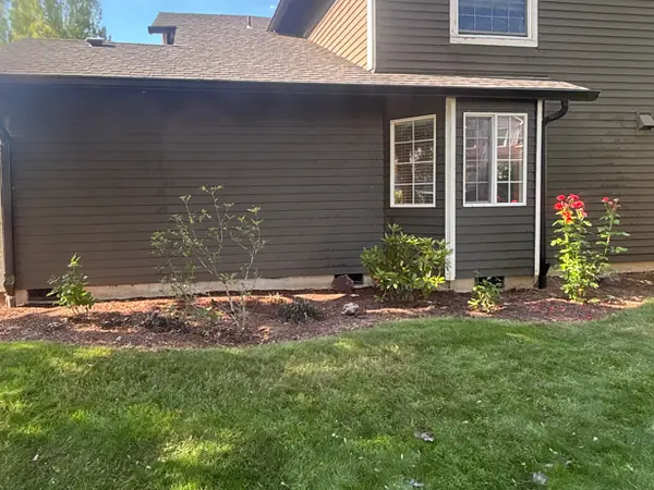 Brown lap-siding Hillsboro home with black gutters and downspouts matched to the siding