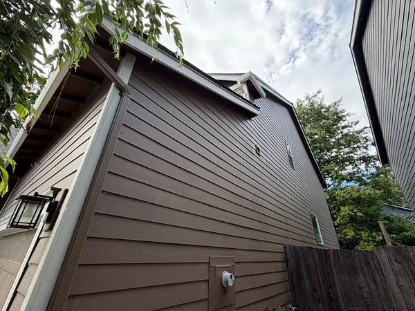 Two-story brown-sided St. Helens home with seamless gutters along the upper and lower rooflines