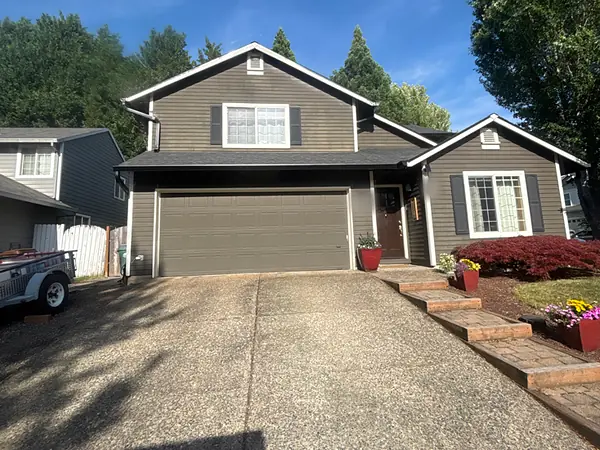 Two-story Hillsboro subdivision home with gray siding and dark gutters and downspouts that match the trim