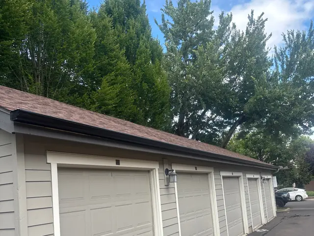 Row of attached garages in Wilsonville with a dark gutter running the length of the roof edge