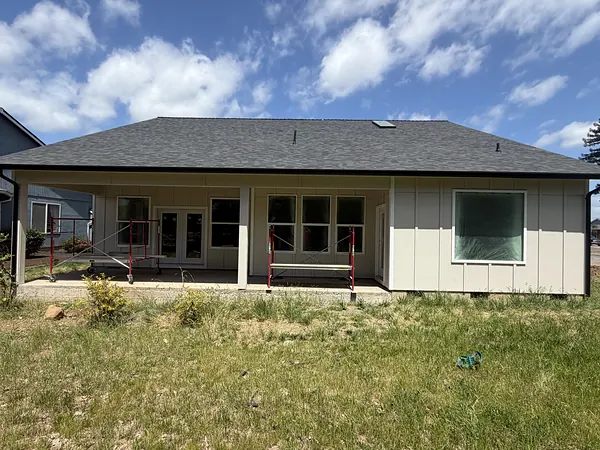 Newly built single-story Scappoose ranch with black seamless gutters along a covered back patio
