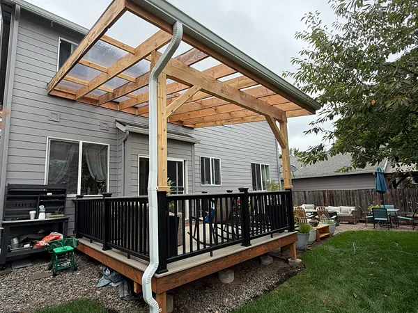 New cedar pergola deck cover on a gray St. Helens home with a seamless gutter and white downspout at the corner post
