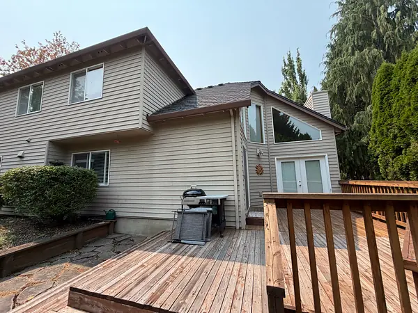 Two-story Aloha home with brown gutters and downspouts above a wood back deck