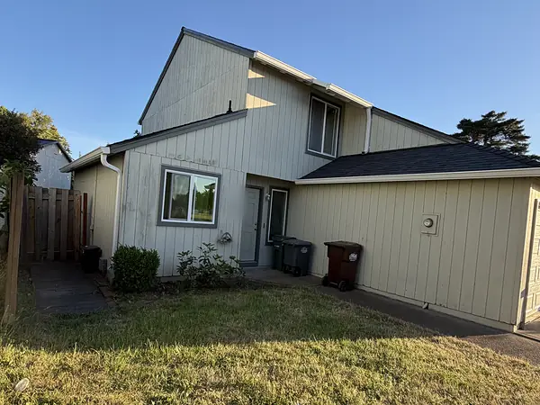 Older Hillsboro home with vertical T1-11 siding, white gutters and a white downspout beside the front walk