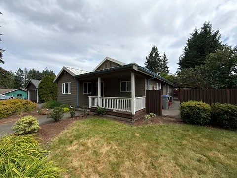 Brown single-story home with a white covered porch and new blue gutters in Tigard, Oregon