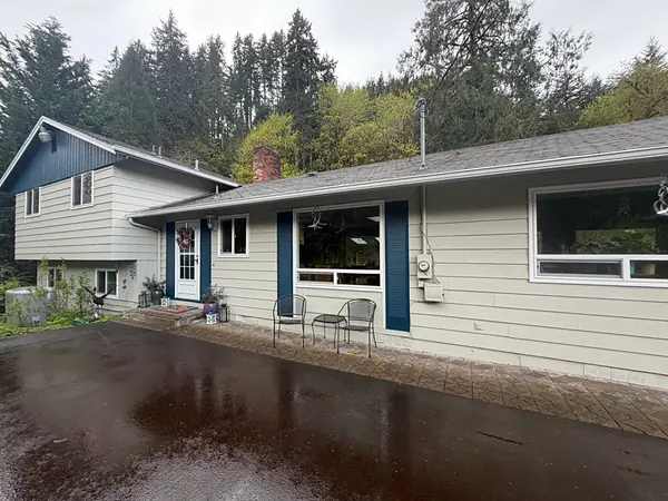 Vernonia ranch home with new seamless gutters along the roofline and a driveway still wet from rain